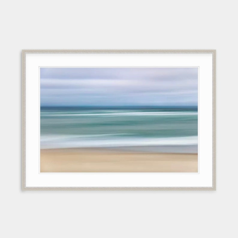 May include: Abstract painting of a beach scene with a blurred background of blue sky, green water, and white waves. The foreground is a sandy beach.