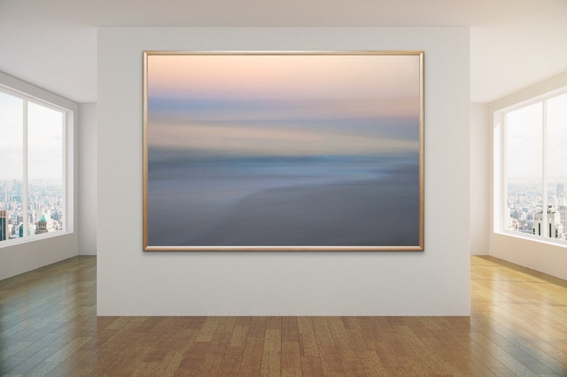 May include: A framed abstract photograph of a blurred seascape with soft pastel colors of pink, blue, and white.