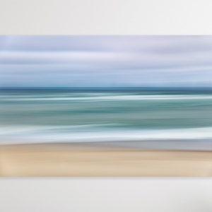 May include: Abstract painting of a beach scene with a blurred sky, ocean, and sand. The colors are soft and muted, with shades of blue, green, and beige.
