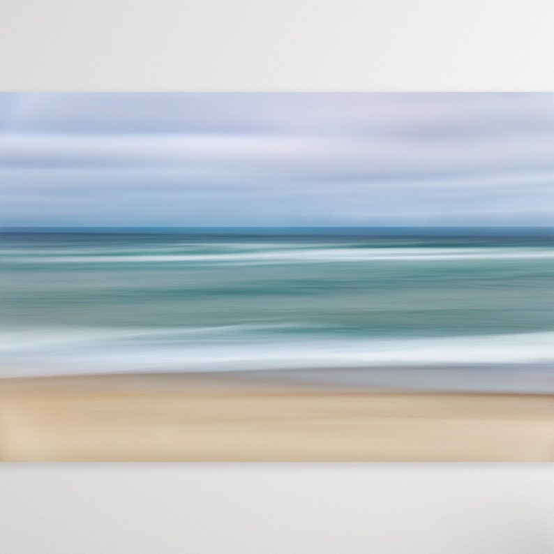 May include: Abstract painting of a beach scene with a blurred sky, ocean, and sand. The colors are soft and muted, with shades of blue, green, and beige.