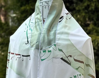 May include: White prayer shawl with green and brown Hebrew text on a white background. The shawl has a green satin trim.