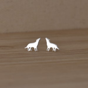 May include: A pair of silver wolf silhouette stud earrings. The earrings are small and delicate, and they would make a great gift for any wolf lover.