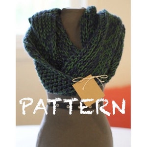 May include: A green and blue knitted scarf with a brown tag that says "PATTERN" on a grey mannequin.
