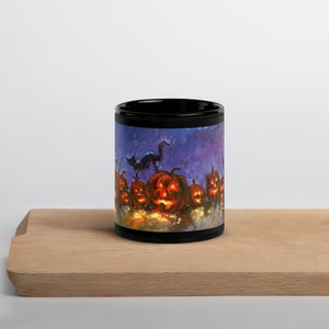 May include: Black coffee mug with a Halloween themed design. The design features a black cat walking past a row of lit jack-o'-lanterns against a purple and blue background.