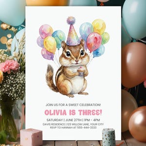 May include: A birthday invitation featuring a watercolor illustration of a chipmunk holding a cupcake and colorful balloons. The invitation text reads "OLIVIA IS THREE!" with event details. The design is set against a backdrop of balloons and flowers.