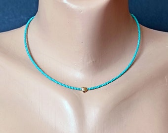 petit tour de cou en perles turquoise avec un petit cœur en or