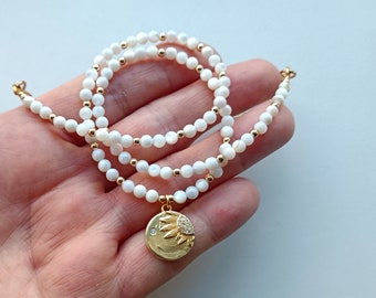 mother-of-pearl necklace with gold sun pendant