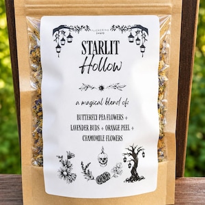 May include: A brown kraft paper pouch containing a dried herbal tea blend. The white label features the text Starlit Hollow, a magical blend of: Butterfly Pea Flowers + Lavender Buds + Orange Peel + Chamomile Flowers, with black ink illustrations.