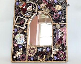 Jeweled wall mirror with purple vintage jewelry