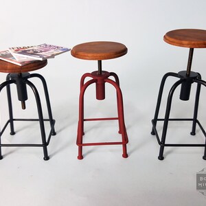 May include: Three adjustable height stools with wooden seats and metal frames. One stool is red, and the other two are black.
