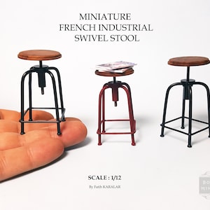 May include: Three miniature French industrial swivel stools, one red, one black, and one with a natural wood seat. The stools are 1/12 scale and are made of metal with a wood seat. The stools are on a white background.
