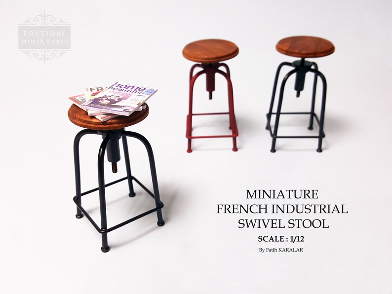 May include: Three miniature French industrial swivel stools. One stool is black with a wooden seat and has a stack of magazines on top. The other two stools are red and black with wooden seats.