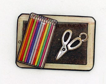 Pin's slate, colored pencils and scissors