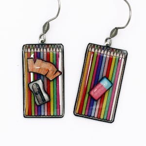 Earrings boxes of colored pencils, eraser and pencil sharpener