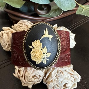 Pulsera de piel con camafeo de colibrí: banda marrón repujada.