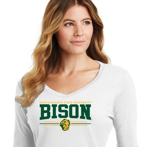 May include: White long-sleeve V-neck shirt with the text "NORTH DAKOTA STATE UNIVERSITY" above the word "BISON" in green and gold. A graphic of a bison head is below the word "BISON". The shirt is a solid white color.