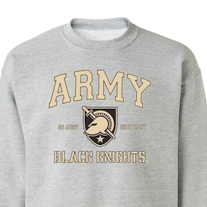 May include: A gray sweatshirt with the words "Army" and "Black Knights" printed on the front in gold. The sweatshirt also features a gold shield with a knight's helmet and sword.
