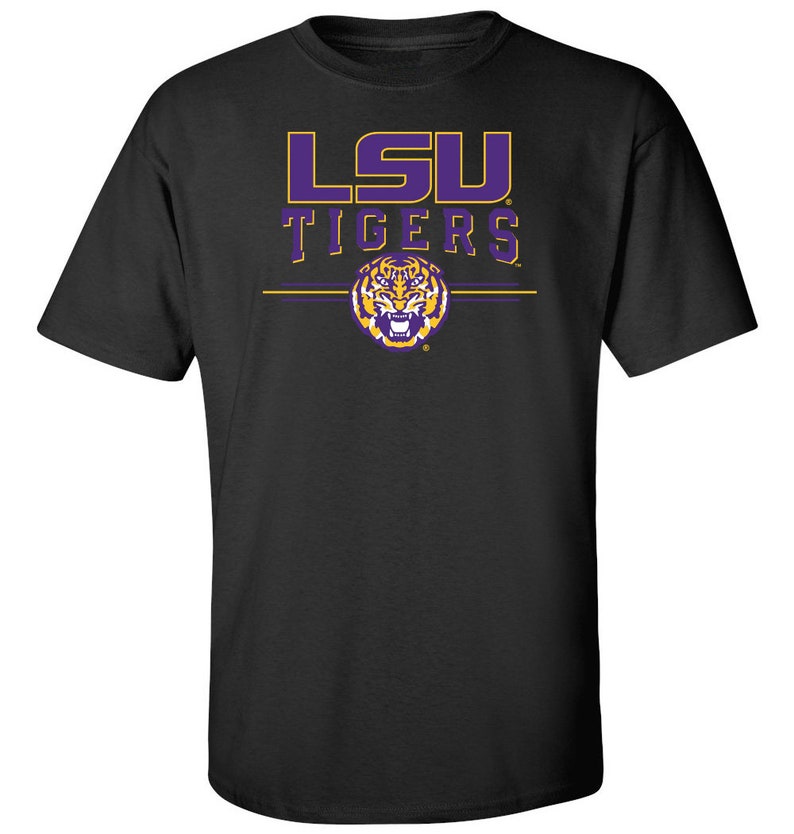 Puede incluir: Camiseta negra con un logotipo de LSU Tigers en morado y dorado y un gr&aacute;fico de cabeza de tigre.