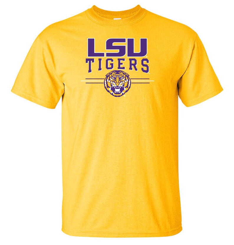Puede incluir: Una camiseta amarilla con las palabras "LSU TIGERS" en letras moradas y un logotipo de cabeza de tigre morado.