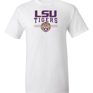 Puede incluir: Camiseta blanca con un logotipo morado de LSU Tigers y un gr&aacute;fico de cabeza de tigre.