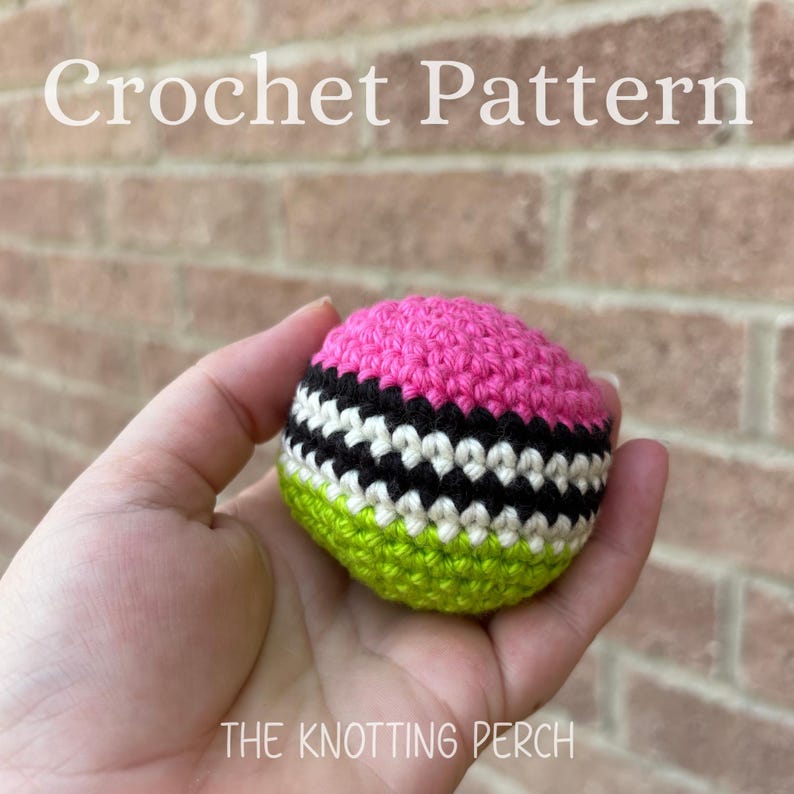 May include: A spherical crochet object featuring horizontal stripes in bright pink, black, white, and lime green. The text "Crochet Pattern" appears at the top and "THE KNOTTING PERCH" is printed at the bottom of the image.