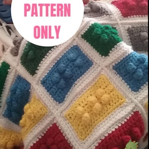 Könnte beinhalten: Eine handgefertigte Häkeldecke mit einem farbenfrohen Blockdesign in Rot, Gelb, Blau, Grün und Grau. Die Decke hat einen weißen Rand und den Text "DIGITAL PATTERN ONLY" in einem rosa Kreis.