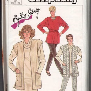 May include: A Simplicity sewing pattern envelope 7762 featuring illustrations of three outfits: a long beige vest over a dress, a red belted tunic with dark pants, and a patterned vest over a turtleneck and matching trousers, labeled Phyllis Sidney.