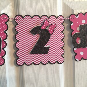 May include: Pink and black birthday banner with the words "Happy 2nd Birthday". The banner has a chevron pattern, polka dots, and a black bow with a rhinestone.