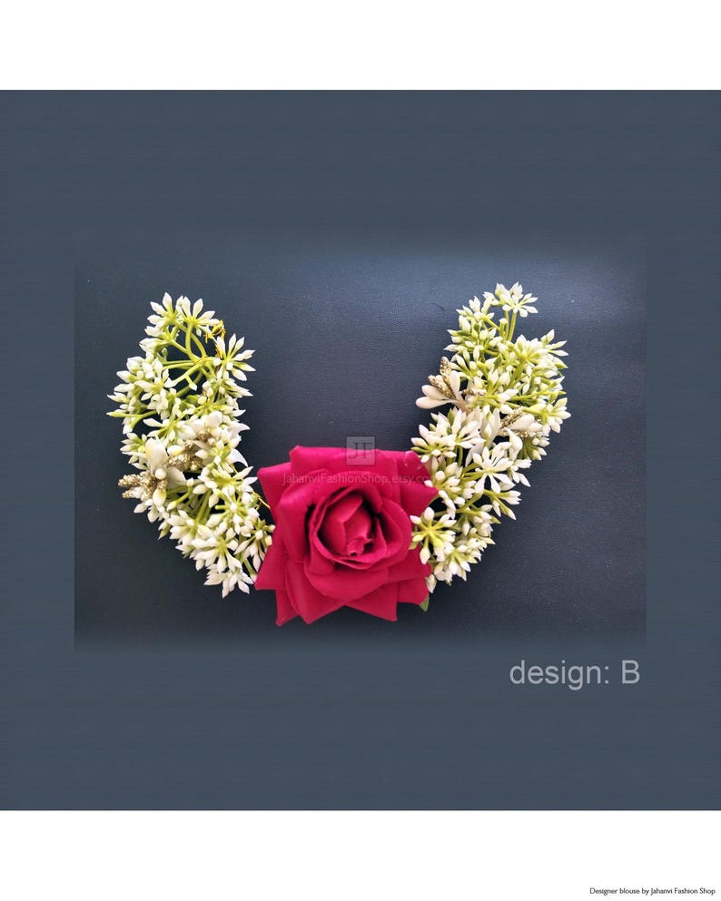 May include: A floral hair accessory featuring a deep red rose at the center, flanked by white and green floral arrangements. The design is set against a dark background, with the text "design: B" visible.
