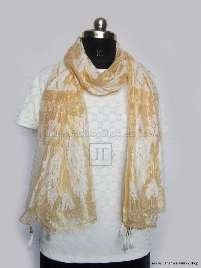 May include: A gold and white scarf with a floral pattern is draped over a white shirt on a mannequin. The scarf has a sheer, flowing texture and is adorned with tassels at the ends. The text "JahanviFashionShop.etsy.com" is visible on the shirt.