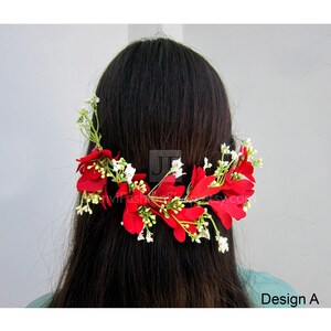 May include: A floral hair accessory featuring vibrant red petals and small white blossoms. The design, labeled "Design A," is arranged on a green stem, creating a natural and elegant look. The accessory is set against a neutral background.