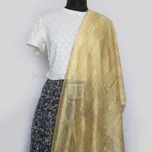 May include: A mannequin displays a white t-shirt, a navy blue floral skirt, and a gold-colored scarf. The scarf has a textured pattern and drapes over the mannequin's shoulder. The text "JahanviFashionShop.etsy.com" is visible.