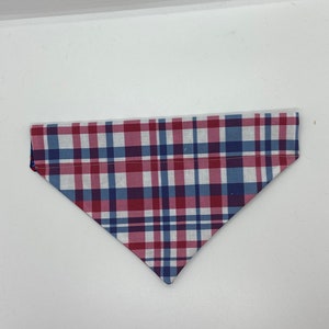 Könnte beinhalten: Ein rotes, weißes und blaues kariertes Hundehalstuch. Das Halstuch ist dreieckig und hat einen weißen Hintergrund mit roten und blauen Karos.