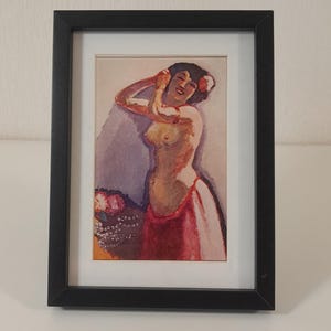 Può includere: Opera d'arte incorniciata raffigurante una figura nuda con una gonna rossa e fiori tra i capelli. Il dipinto ha una calda tavolozza di colori con sfumature di rosso, rosa e beige. L'opera è esposta in una cornice nera.