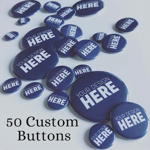 May include: A selection of navy blue custom buttons, featuring the text "YOUR DESIGN HERE" in white. The buttons are of different sizes and are arranged on a white background. The text "50 Custom Buttons" is at the bottom.