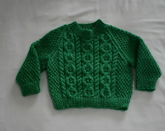 Pull bébé tricoté à la main en Irlande avec des câbles Aran