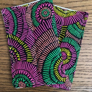 May include: Two black fabric pot holders with a colorful geometric pattern of pink, green, and yellow circles on a black background.