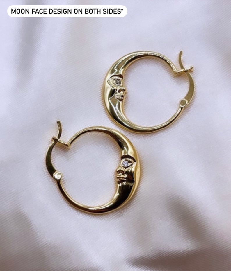 May include: Gold-colored hoop earrings with a crescent moon design. Each earring features a moon face with a small, clear gem. The text "MOON FACE DESIGN ON BOTH SIDES*" is visible at the top.