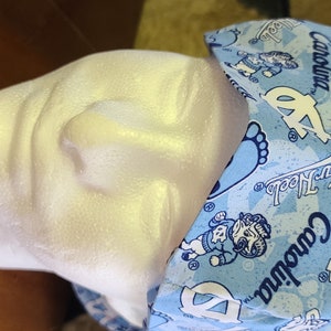 May include: A blue and white patterned surgical scrub hat with the text "Carolina" and "Tar Heels" repeated throughout the design.