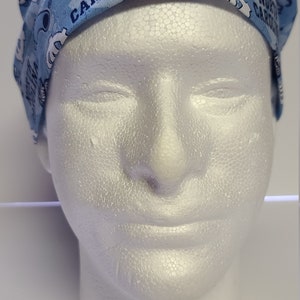 May include: A light blue scrub hat with a white and blue pattern featuring the words "North Carolina" and "UNC".