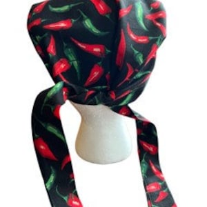May include: Black scrub hat with a red and green chili pepper pattern. The hat has long ties that can be tied at the back of the neck.