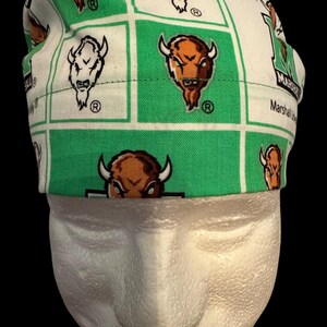 May include: Green and white fabric scrub hat with a repeated pattern of brown and white buffalo heads and the text "Marshall University".