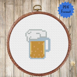 May include: A pixelated cross-stitch pattern of a glass of beer with a white foam head.