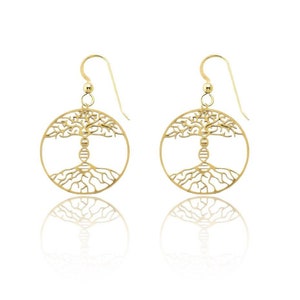 Op de afbeelding: Gouden oorbellen met een rond ontwerp met een levensboom met ingewikkelde takken en wortels. De boom is gecentreerd rond een dubbele helix, wat de verbinding tussen natuur en wetenschap symboliseert.
