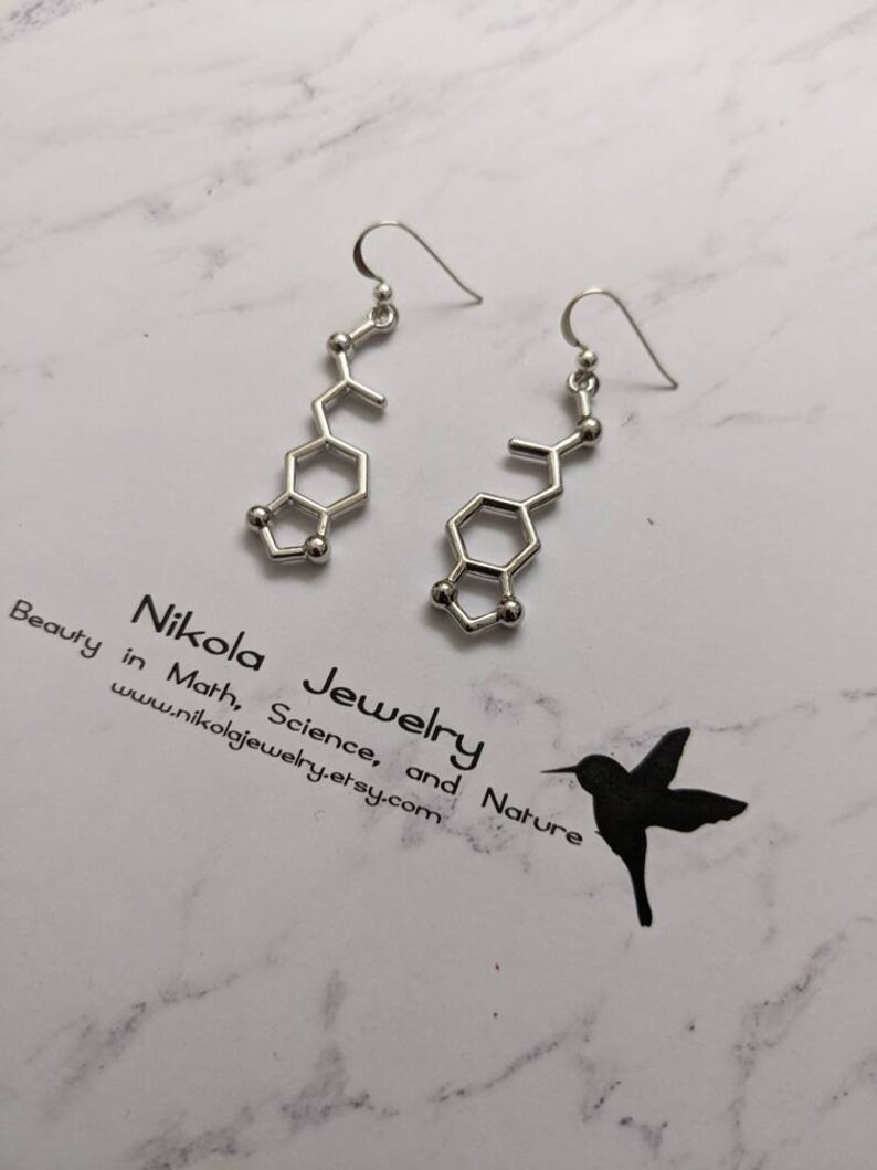 May include: Silver earrings shaped like a chemical molecule, with a hook closure. The earrings are on a white marble background with the text "Nikola Jewelry Beauty in Math, Science, and Nature www.nikolajewelry.etsy.com".