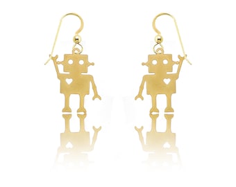 May include: Gold robot earrings with a heart cutout. The robots are holding a small stick in their hands.