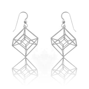 May include: A pair of silver geometric dangle earrings with a cube-shaped design. The earrings are made of a thin, wire-like material and have a delicate, openwork design.