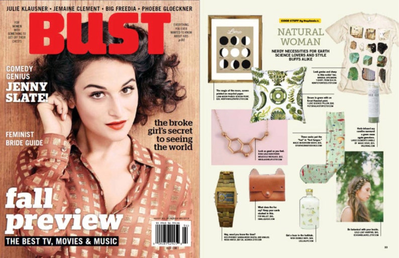 May include: A magazine cover featuring a woman with dark hair and a red lip. The magazine is titled "Bust" and the cover story is "The broke girl's secret to seeing the world". The cover also features the text "Fall Preview" and "The Best TV, Movies & Music". The right side of the image shows a spread of products with a natural theme, including a t-shirt with a print of rocks and minerals, a pillow with a botanical print, a necklace with a chemical structure pendant, a watch with a wooden band, a leather wallet, and a bottle of liquid.