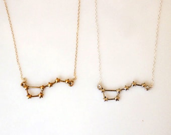 May include: Two delicate necklaces with a constellation design. One necklace is gold and the other is silver.