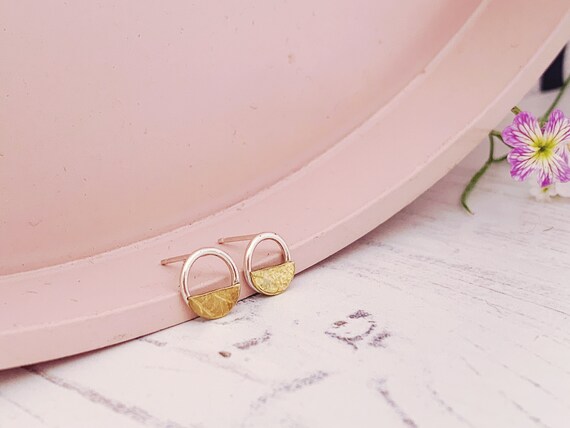 Minimal circle and half-moon studs made with recycled sterling silver and brass. petal/leaf pattern.